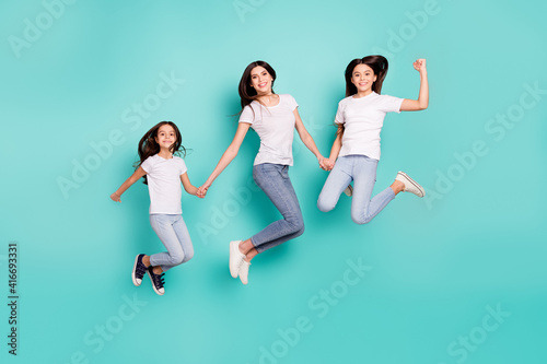 Full length body size photo sisters jumping up wearing casual outfits happy won lottery isolated vivid blue color background