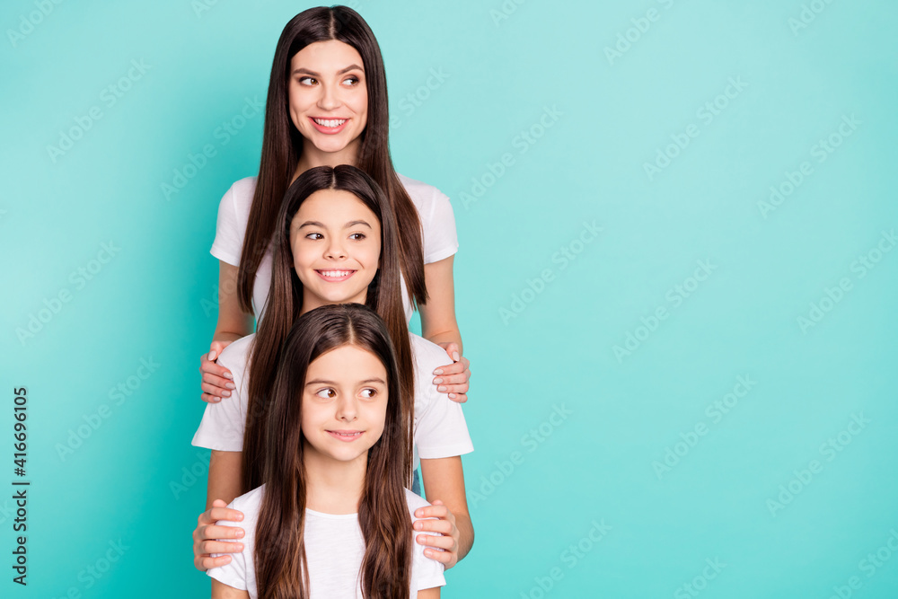 Photo portrait of three sisters different generations smiling curious looking blank space isolated vibrant blue color background Photo portrait of three sisters different generations smiling curious looking blank space isolated vibrant blue color background