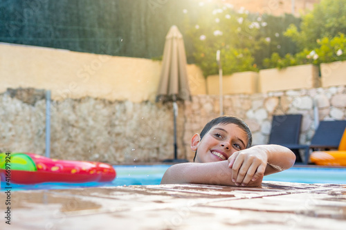 Funny kid smiling on a pool side