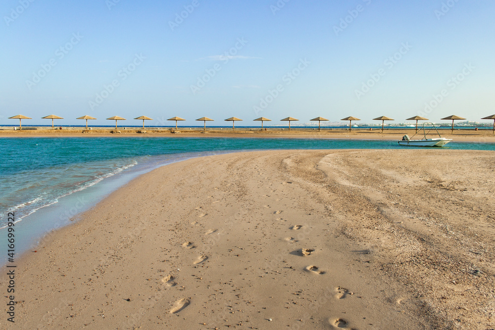 Obraz premium Sunset on the beach with parasol overlooking the Red Sea in Hurghada, Egypt