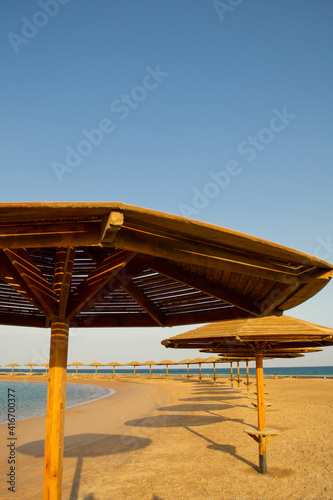 Fototapeta Naklejka Na Ścianę i Meble -  Sunset on the beach with parasol overlooking the Red Sea in Hurghada, Egypt