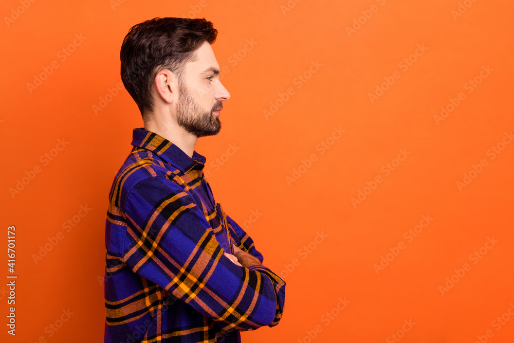 Fototapeta premium Profile side photo of young handsome man confident folded hands look empty space isolated over orange color background