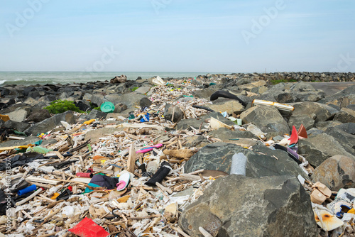 Spilled garbage on the beach near the big city. Empty used dirty plastic bottles and other garbage. Dirty seashore the Tyrrhenian sea. Environmental pollution. Ecological problem.
