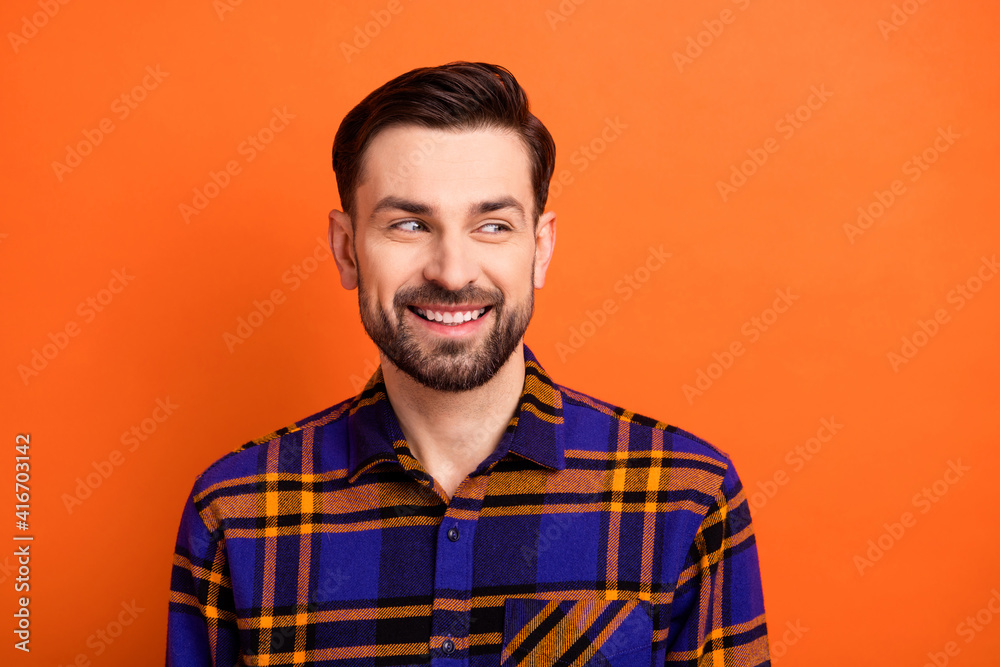Photo of young handsome man beard happy positive smile dream look empty space isolated over orange color background