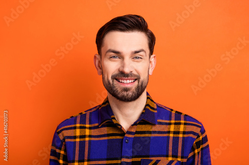 Photo of young handsome man happy positive smile wear casual shirt isolated over orange color background © deagreez
