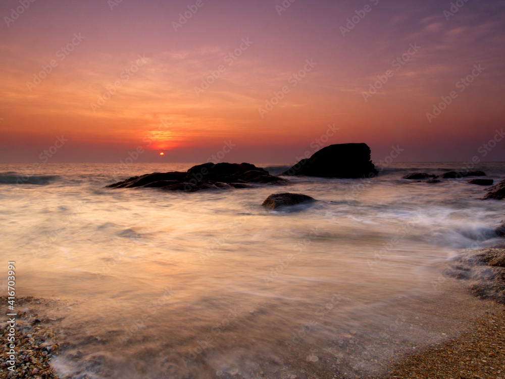 Beautiful natural seascape wave hit the rock during sunrise