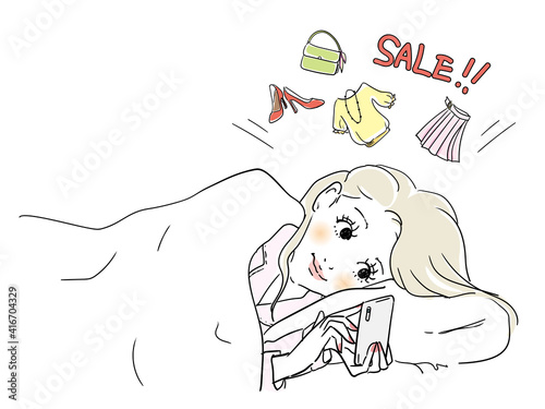 ベッドでネットショッピングに夢中な女性