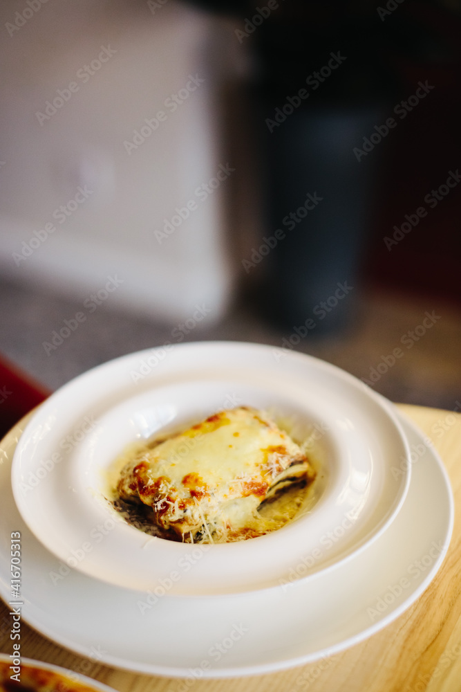Serving delicious Italian Lasagne in a deep and round plate Serving delicious Italian Lasagne in a deep and round plate