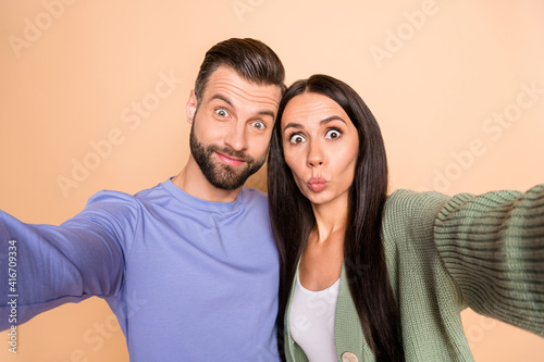Photo of optimistic couple do selfie wear sweater isolated on beige color background
