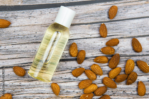 almond oil in a transparent bottle with nuts on the background top view