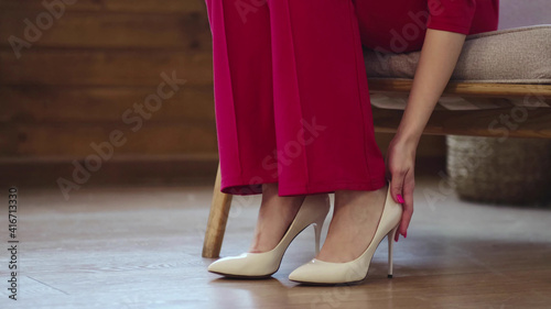 tired business woman takes off her shoes after a long day. swelling of feet after high heels, soft focus. Selective focus.