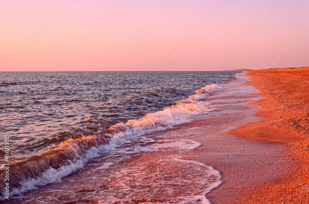 Coastline. Beautiful seascape on a summer morning, pink sunrise.