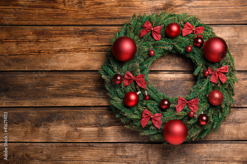 Beautiful Christmas wreath on wooden background, top view. Space for text