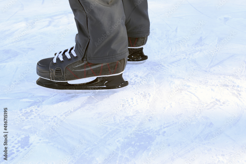 Russia, Chelyabinsk, February 25, 2021: An athlete in ice hockey skates on the rink. View only feet. Russia, Chelyabinsk, February 25, 2021: An athlete in ice hockey skates on the rink. View only feet.