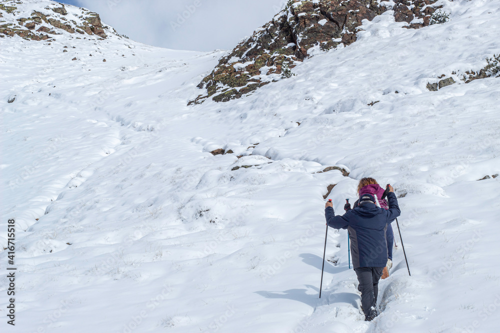Excursionistas subiendo una montaña nevada