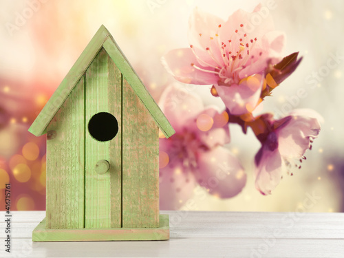 Beautiful bird house on wooden table outdoors, space for text