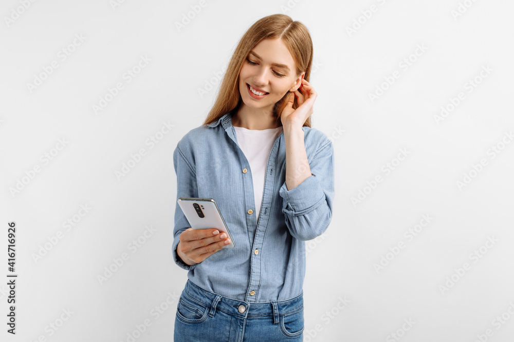 young woman using mobile phone looking at smartphone screen on white background young woman using mobile phone looking at smartphone screen on white background