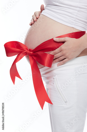 Wallpaper Mural A belly of pregnant woman with red ribbon isolated on a white background. Torontodigital.ca