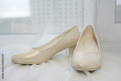 Beautiful white wedding shoes with rhinestones. Stylish bride's room.