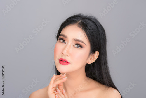 Beauty and healthcare. Portrait of young and beautiful asian woman on gray background 