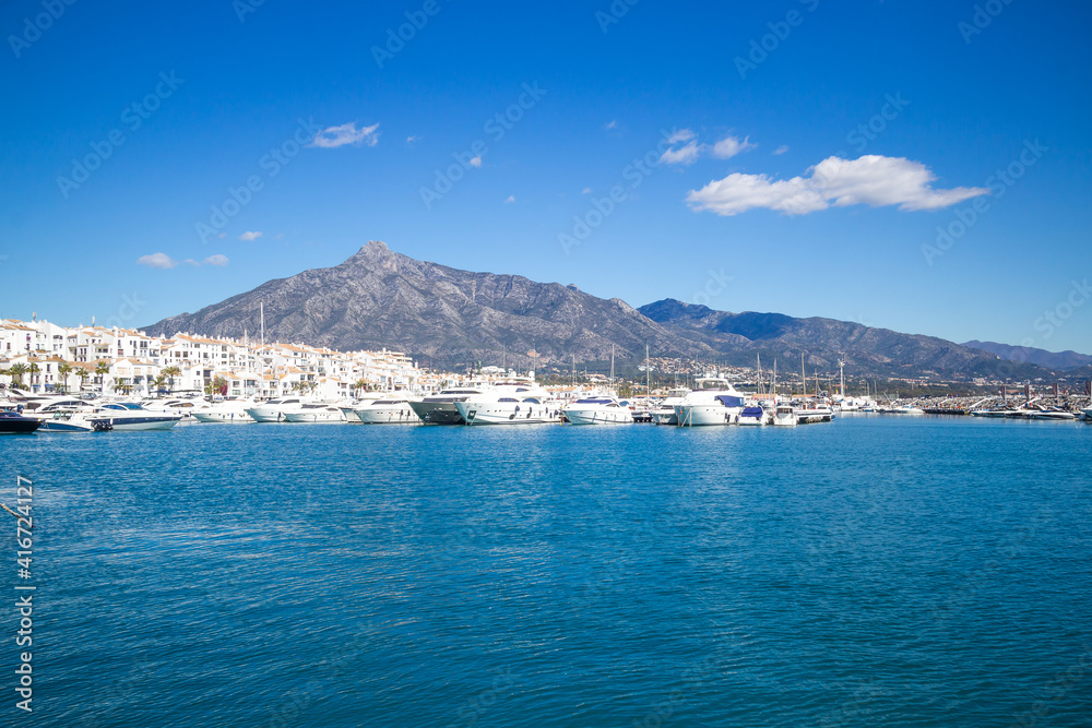 View of Puerto Banus marina with boats and white houses in Marbella town at sunrise, Andalusia, Spain View of Puerto Banus marina with boats and white houses in Marbella town at sunrise, Andalusia, Spain