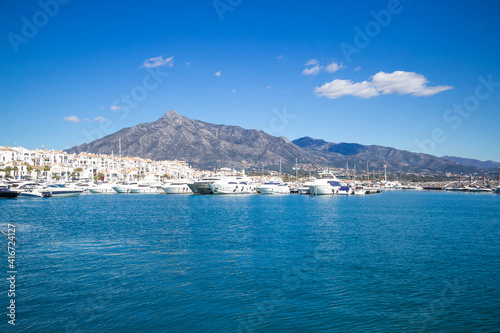 View of Puerto Banus marina with boats and white houses in Marbella town at sunrise, Andalusia, Spain