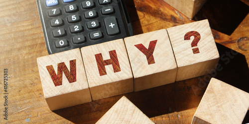 The word Why with quetion mark on wooden Blocks and calculator. Business crisis concept photo
