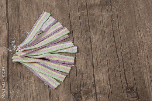 Rainbow narrow long jellybeans on a wooden board