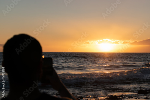 silhouette of young man on the beach taking pictures © Raul Ortiz 