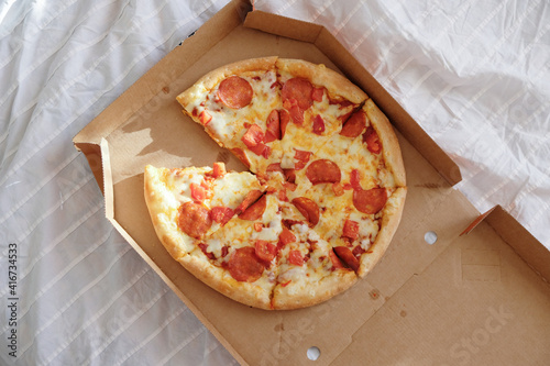 Pepperoni Pizza on the white bed sheet
