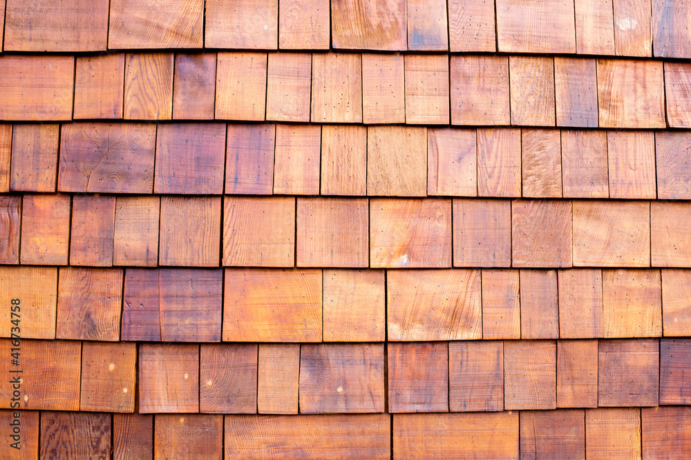 The background of small teak panels connected together as a wall. Wooden background. The background of small teak panels connected together as a wall. Wooden background.