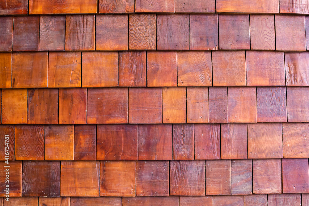 The background of small teak panels connected together as a wall. Wooden background. The background of small teak panels connected together as a wall. Wooden background.