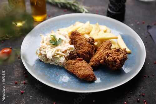 Chicken nuggets with fries and coleslaw. Fast food dinner. The finished dish served on a plate. Serving proposal, culinary photography.