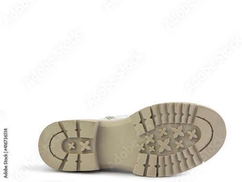 White leather boots with brown laces and zipper on the side. Imitation of crocodile skin. Beige rubber sole. Isolated close-up on white background. Shoe sole view. Fashion shoes.