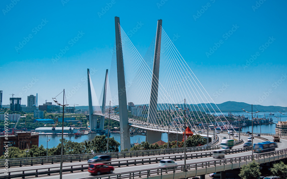 Obraz premium The bridge across the Golden horn bay in Vladivostok in sunny weather. Golden Bridge and view of Vladivostok