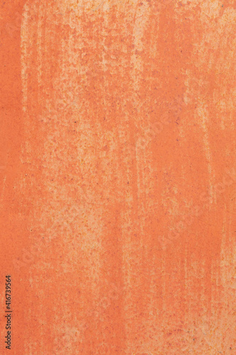 Old texture of rusty sheet metal with peeling orange paint.	