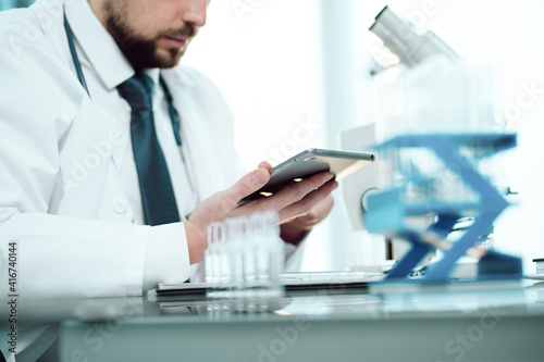 scientist reading his notes in a digital tablet.