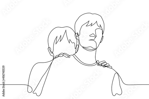 Two men stand and look at the viewer, one of whom is hiding behind the other. friends protection concept; shyness and social awkwardness when meeting new people; fear and phobia of strangers