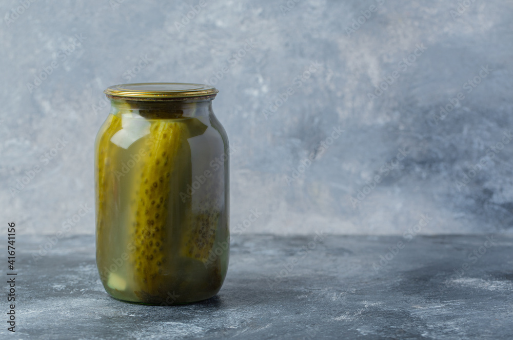 A pickle jar on grey background. Seasonal A pickle jar on grey background. Seasonal