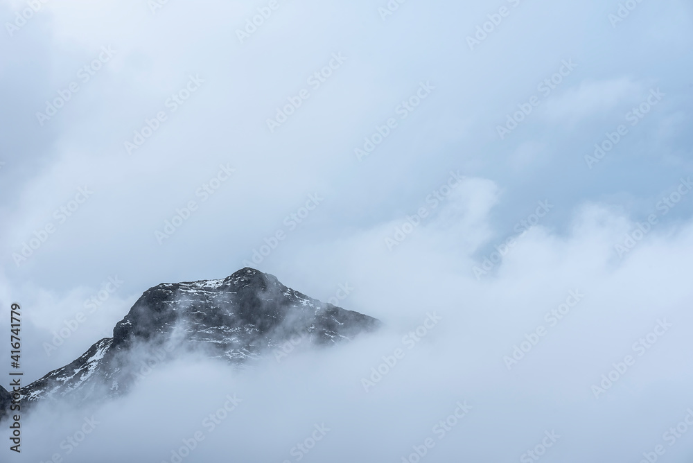 Epic Winter landscape image of view from Side Pike towards Langdale pikes with low level clouds on mountain tops and moody mist swirling around Epic Winter landscape image of view from Side Pike towards Langdale pikes with low level clouds on mountain tops and moody mist swirling around