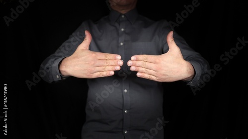 gesturing hands, man delimiting himself, setting limits, signs, gestures, isolated scene against black background 