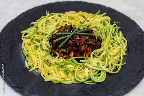 Zucchini spaghetti with shimeji on black stone plate