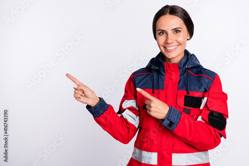 Foto Photo of young woman paramedic happy positive smile indicate fingers empty space
