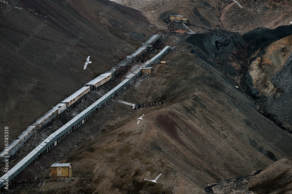 Ruined coal mining facility building with mountain in the background in the Ghost Town of Pyramiden, Svalbard Ruined coal mining facility building with mountain in the background in the Ghost Town of Pyramiden, Svalbard