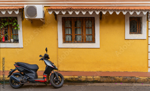 Scooter parked in front of yellow colored wall at fontainhas