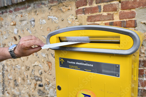 La Poste. Main qui poste une lettre dans une boite aux lettres photo