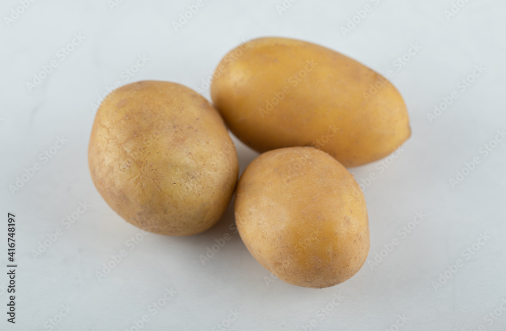 Three organic fresh potatoes. Close up photo Three organic fresh potatoes. Close up photo