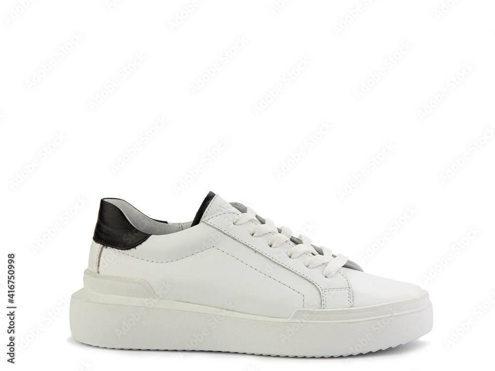 White leather sneakers with black details. Casual women's style. White lacing and white rubber soles. Isolated close-up on white background. Right side view. Fashion shoes.