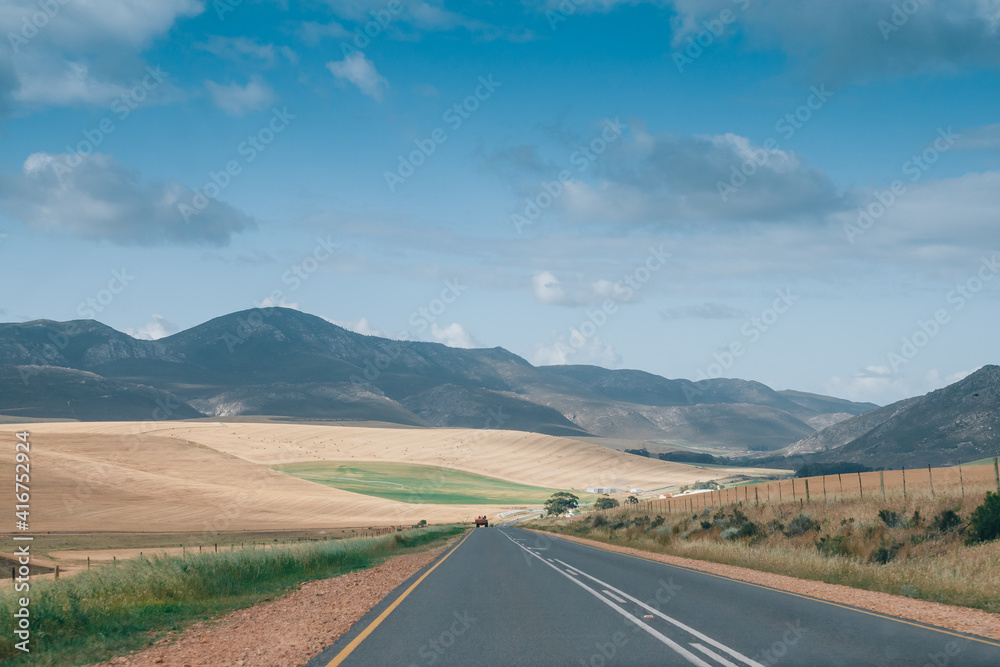picturesque asphalt road among fields and mountains
