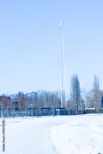 telecommunications tower in the winter under a clear blue sky